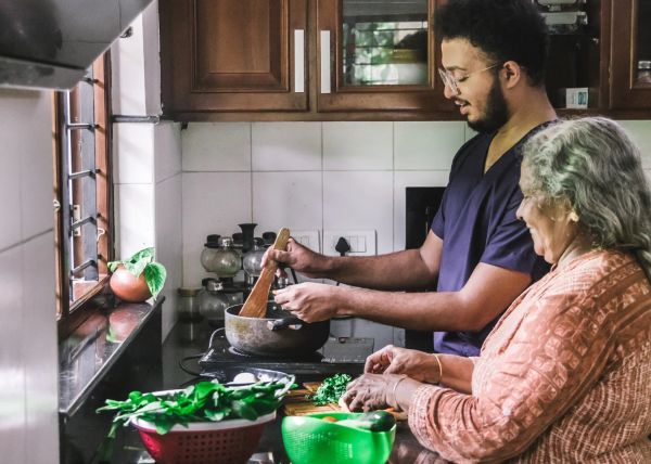 man cooking with older women