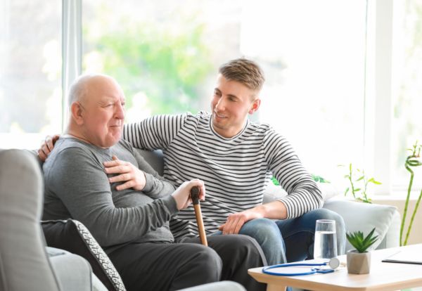 young man sitting with elderly man talking