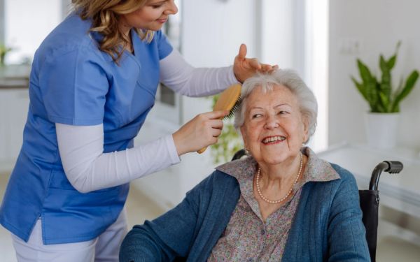 woman helping senior brush hair