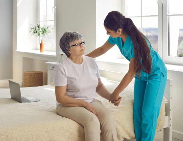 Caregiver helping women to stand