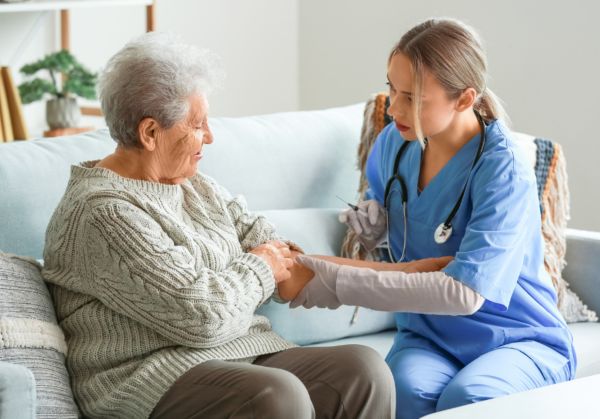 caregiver taking a elder womens blood pressure