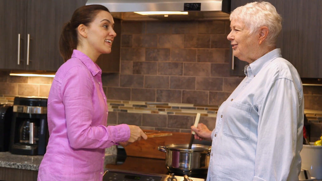 Young nurse cooking with older patient