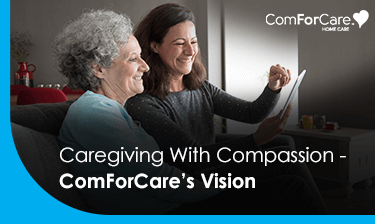 an older woman and her compassionate caregiver looking at something an smiling.