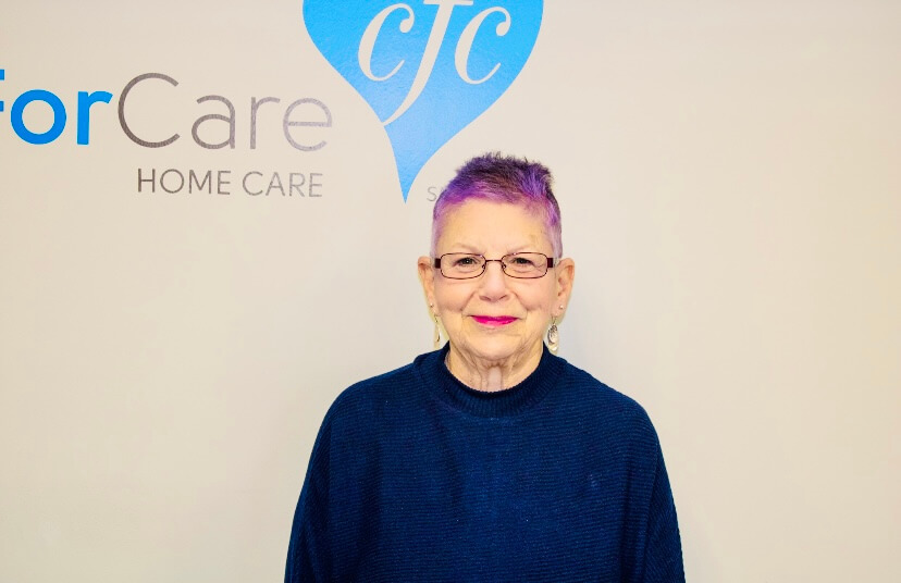 An in-home care nurse smiling next to the logo.