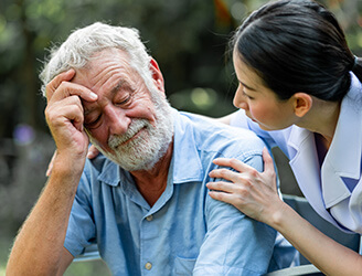 Older man consoled by young nurse