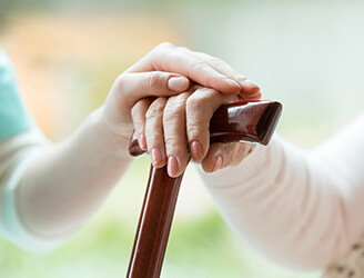 A nurse's hand holding their patient's hand.