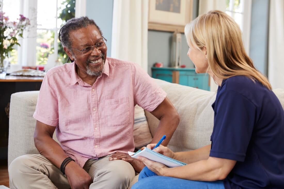 Dementia caregiver with elderly woman looking outside