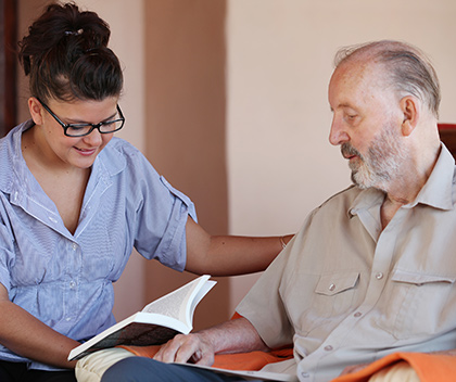 Home nurse reading to older man