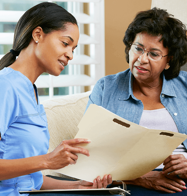 Home nurse going over medical charts with older patient