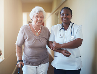 Nurse helping older woman walk