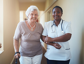 Home nurse walking with older woman