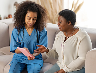 Young nurse going over medical charts with older woman