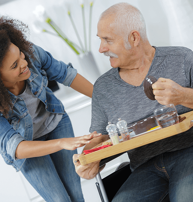 Younger woman bringing food to older man