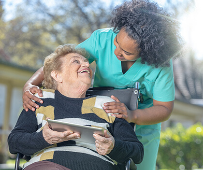 Older woman laughing with young nurse