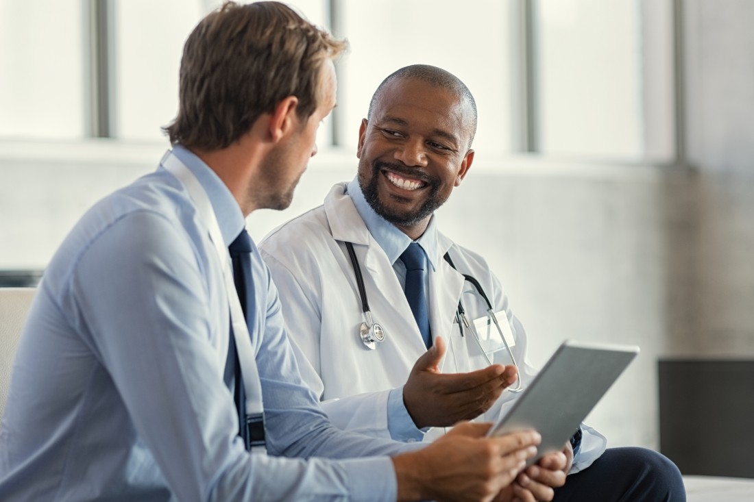 A home care franchisee speaks to a smiling doctor