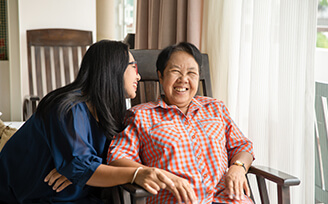 Older woman laughing with young nurse