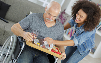 Young nurse helping older man eat