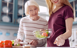 Companionship caregiver and senior making a meal together