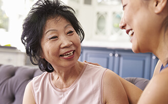 Older woman laughing with younger nurse