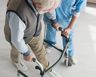 Young nurse helping older man walk