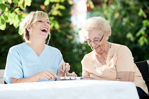 Young woman laughing with elderly woman