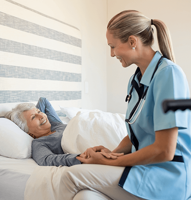 Home nurse at elderly woman's bedside