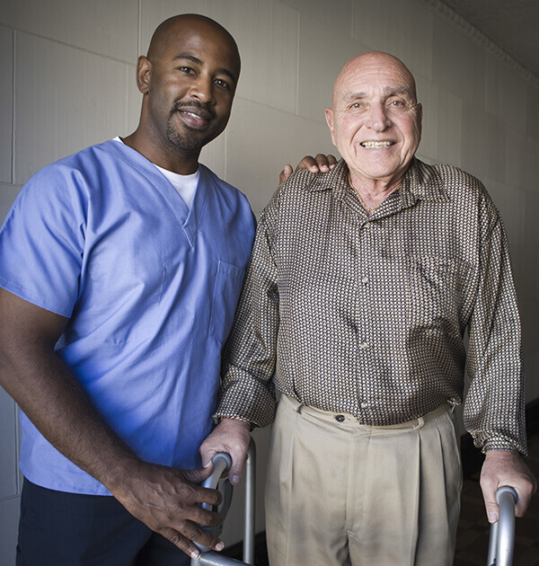 Young nurse smiling with older man