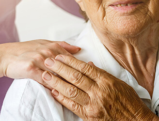 Older woman holding hand of home nurse