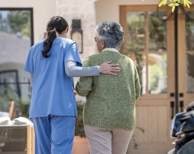 Professional caregiver assisting a senior with reducing hospital readmissions at home.