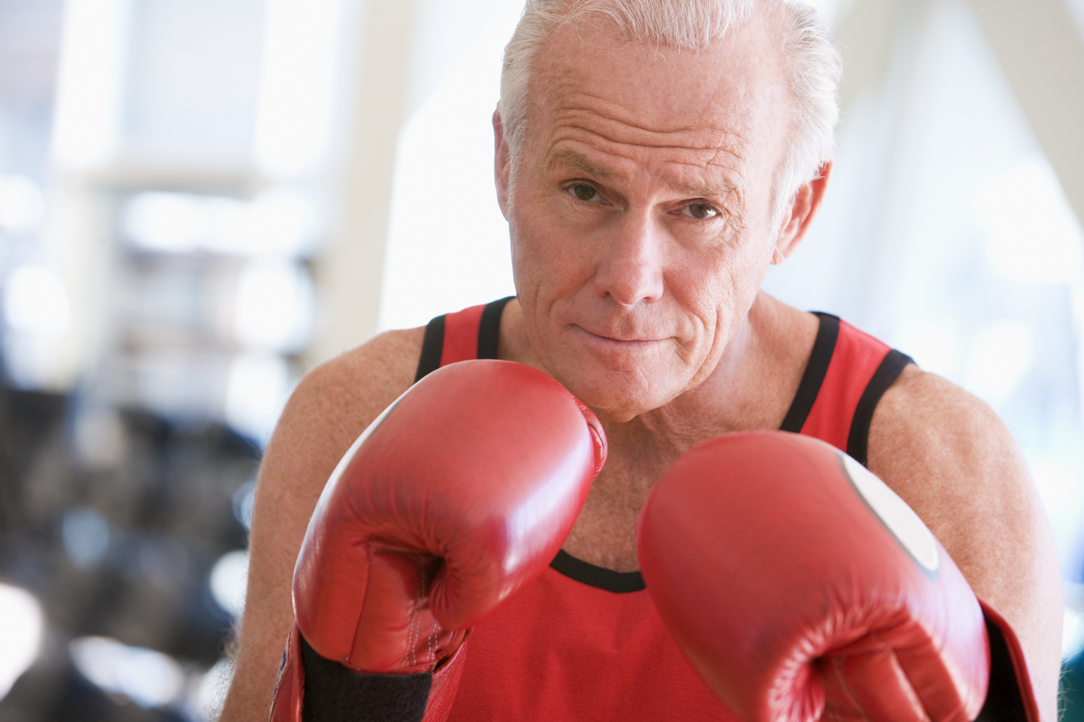 A senior man poses with boxing gloves as part of a Parkinson’s support group in New Braunfels