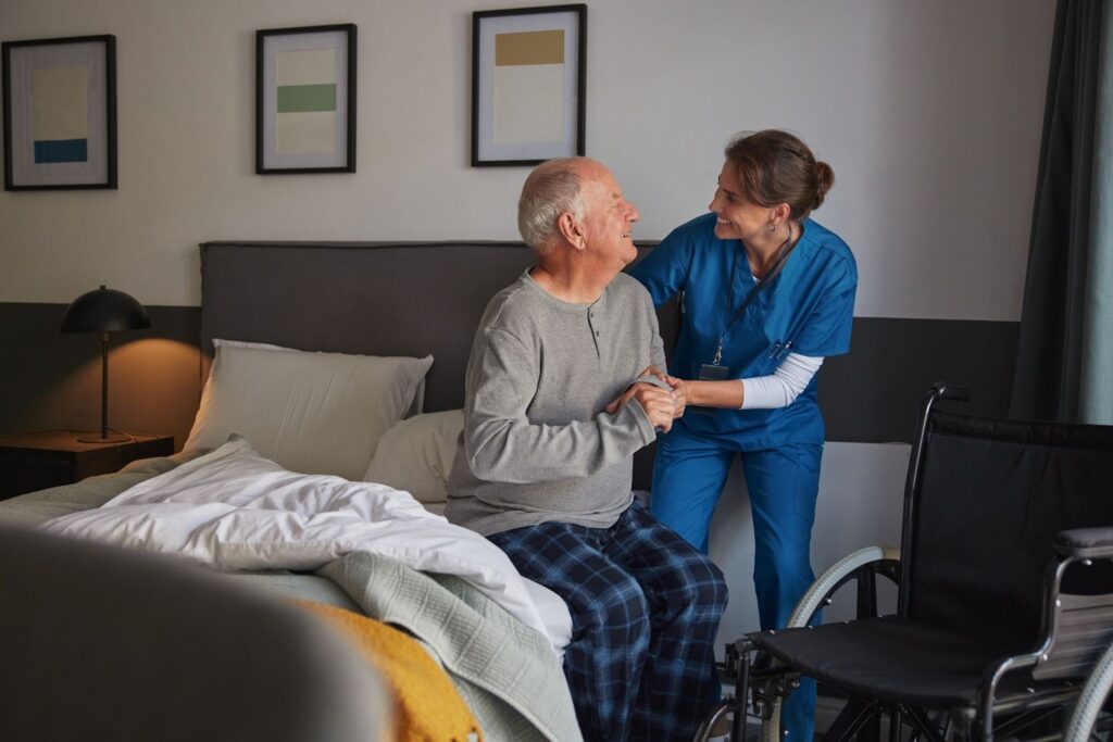 Professional caregiver assisting older adult with daily activities at home.