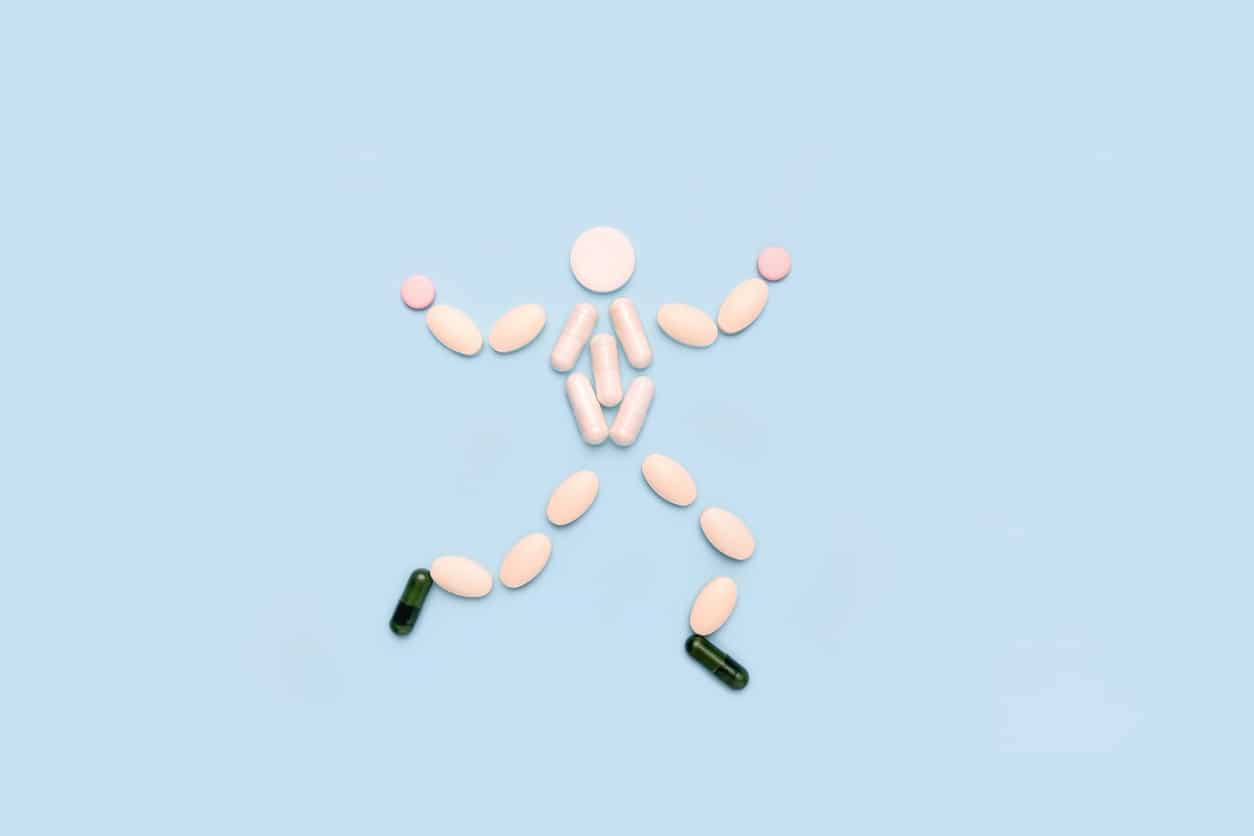 Pills laid out in the shape of a jumping man symbolizing the phrase: “movement is medicine.”
