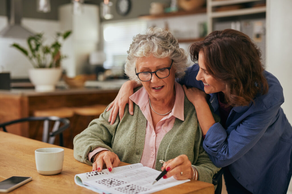 A woman works with her parent on a brain puzzle.