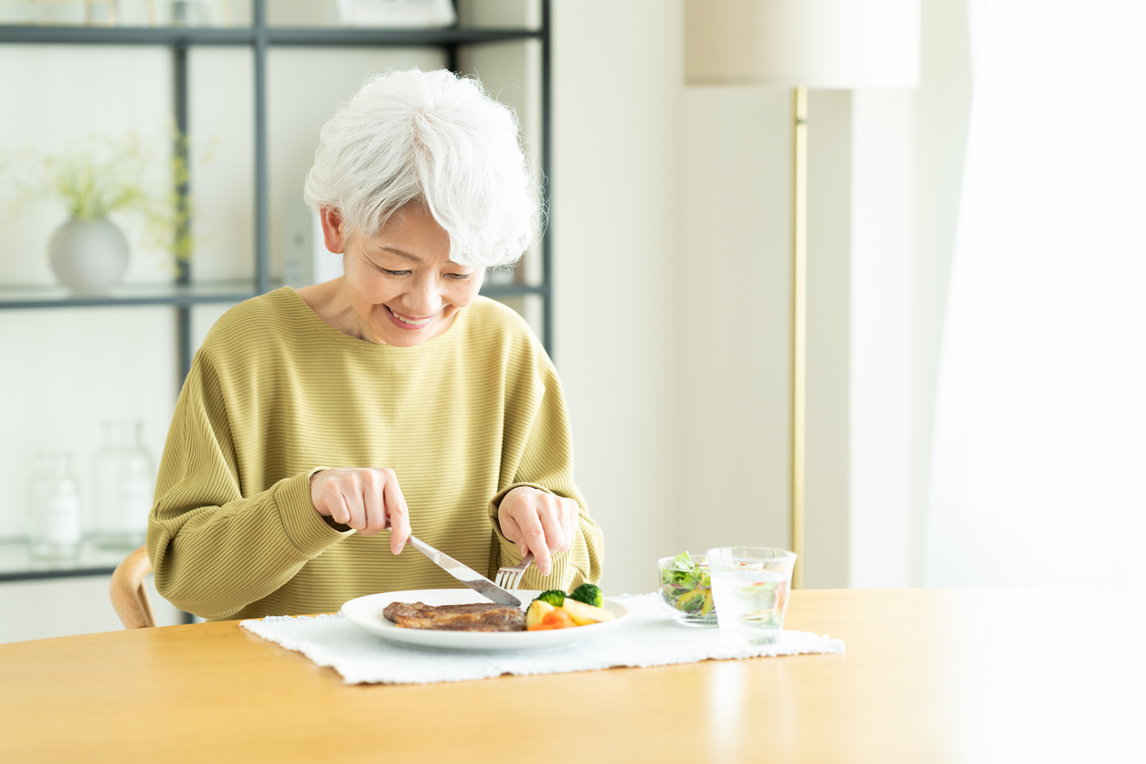A senior woman eating a balanced, protein-rich meal at home in the New Braunfels area.