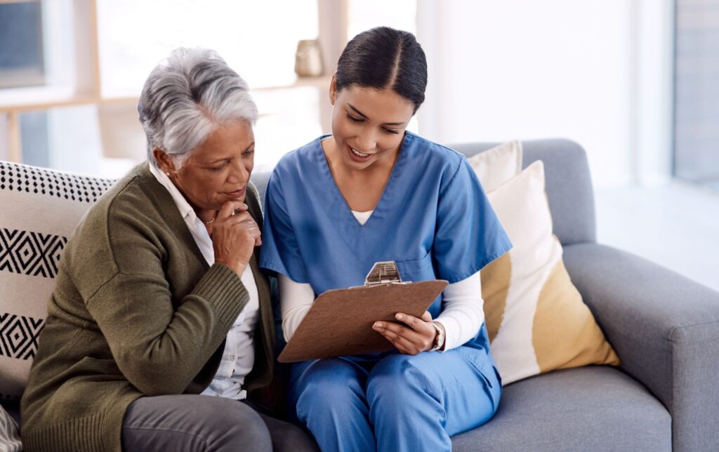 A caregiver reviewing a home safety checklist with an older adult and family member in New Braunfels, TX.