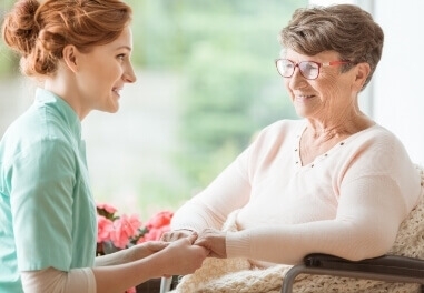 A young woman holding hands of a senior woman in Milwaukee County.
