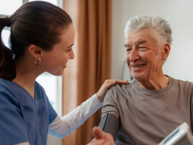 ComForCare Employee Helping Senior Client Check Blood Pressure
