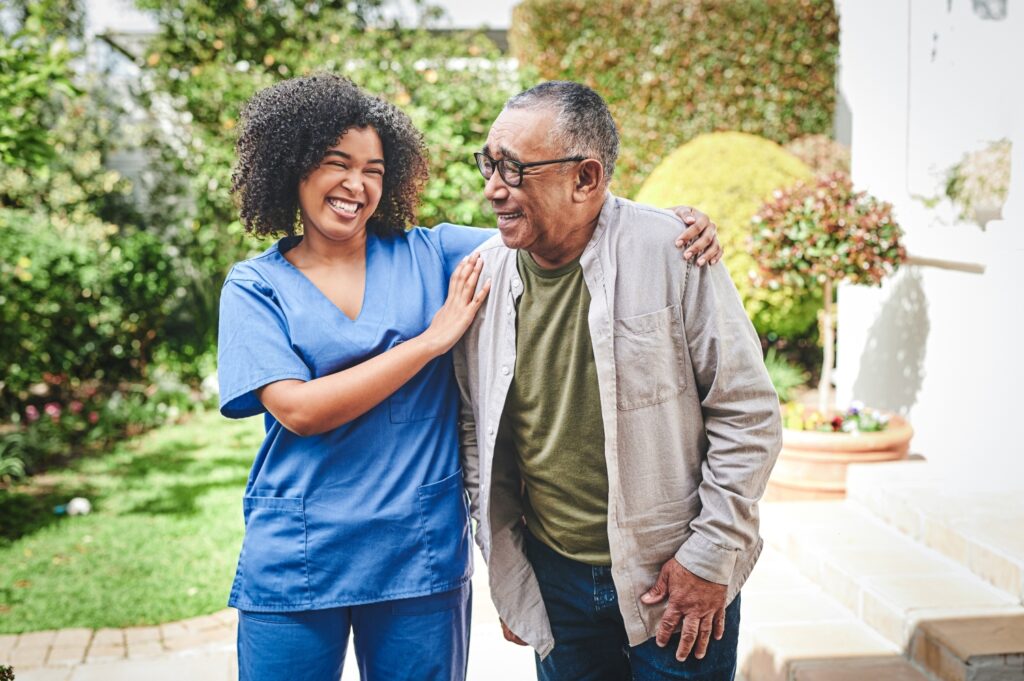A caregiver walking and talking with an older gentleman.
