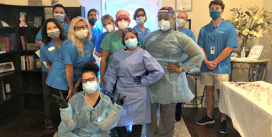 A group of caregivers in PPE posing for a photo.